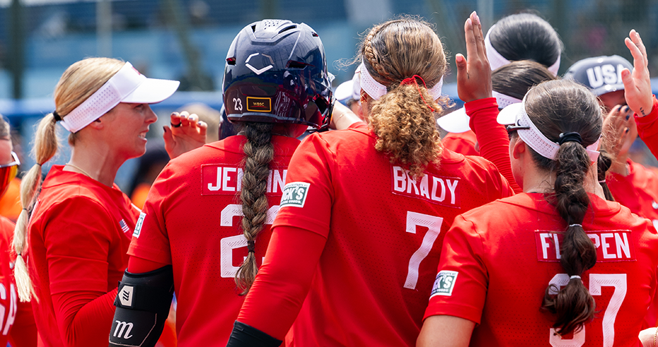Maya Brady, Tiare Jennings, Hannah Flippen among Team USA players in their red jerseys with white numbers in a huddle.